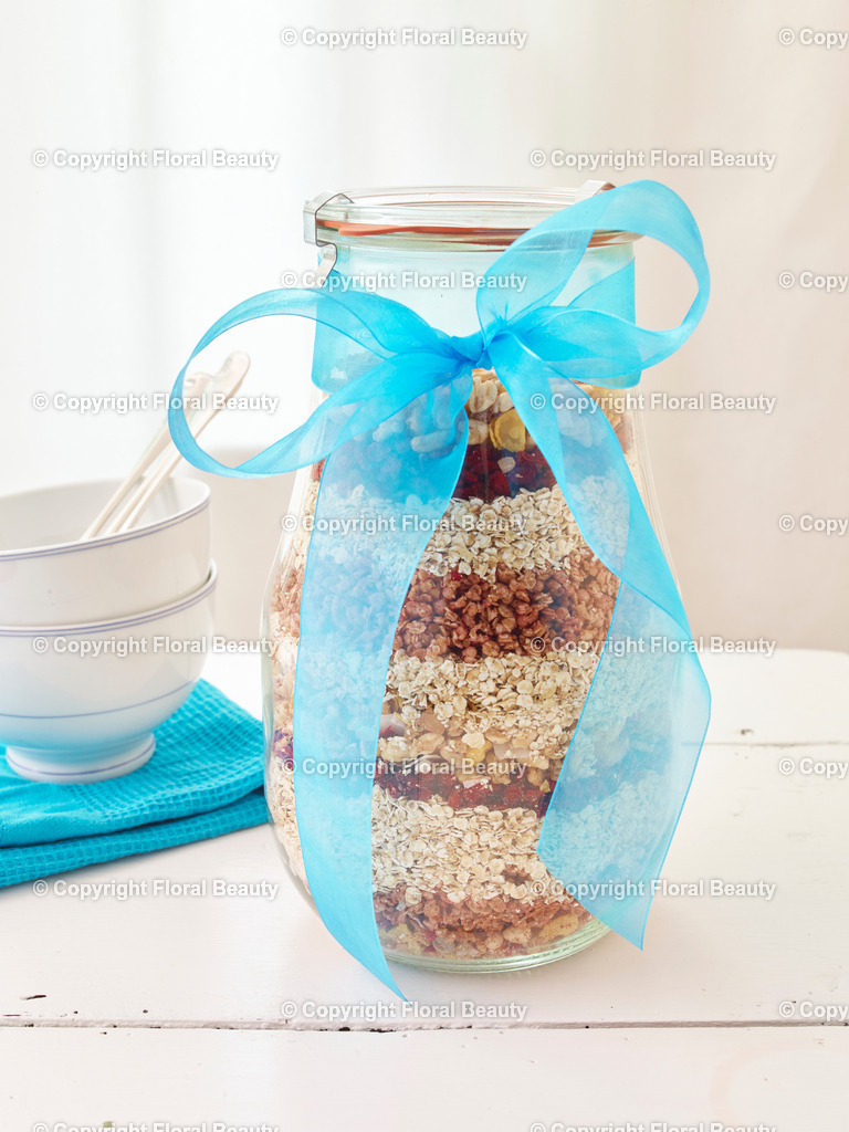 Knuspermüsli | Weckglas mit geschichtetem Müsli aus Haferflocken und Cranberries. Mit blauer Schleife umwickelt. - Realisiert mit Pictrs.com