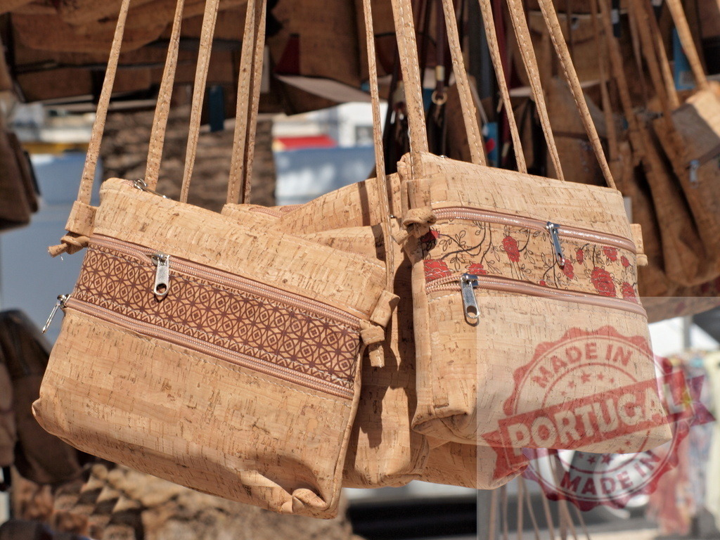 Cork bags hanging for sale at market stall | Cork bags displaying unique patterns available at an outdoor market - Realisiert mit Pictrs.com