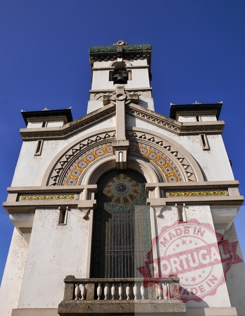 Chapel bell tower against clear blue sky | Ornate chapel bell tower featuring mosaic tile art and a decorative cross against blue sky - Realisiert mit Pictrs.com