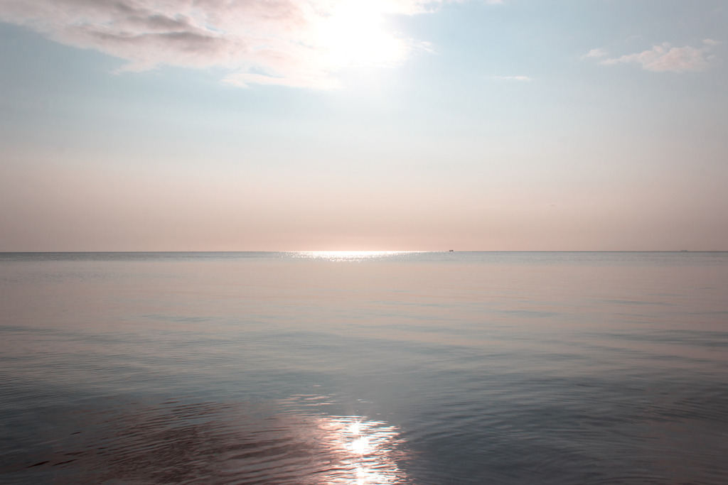 Wandbild: Seidiges Meer im Morgenrot in dezenten Farben | Dieses Wandbild im Querformat zeigt eine wunderschöne Morgenstimmung am Meer. Das Wasser ist ruhig und wirkt seidenartig. Die Sonne kommt gerade wieder hinter einer Wolke hervor und spiegelt sich sowohl in der Ferne als auch im Vordergrund auf dem Meer. Sie möchten Ihre Wände dezent aber stilvoll und elegant dekorieren? Dann holen Sie sich dieses maritime Wandbild. Es ist auf Leinwand, Aluminium-Platte, Acrylglas oder als Holzdruck erhältlich. Die Wandbilder werden individuell für Sie in vielen Abmessungen produziert. Daher passen die Ostseekult Wandbilder immer perfekt an Ihre Wände. - Realisiert mit Pictrs.com