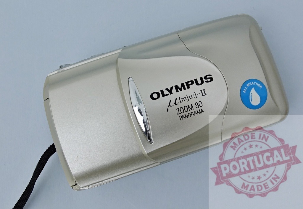 Olympus μ[mju:]-II Zoom 80 Panorama point and shoot camera | Olympus µ[mju:]-II Zoom 80 Panorama vintage 35mm film camera on a light background - Realized with Pictrs.com