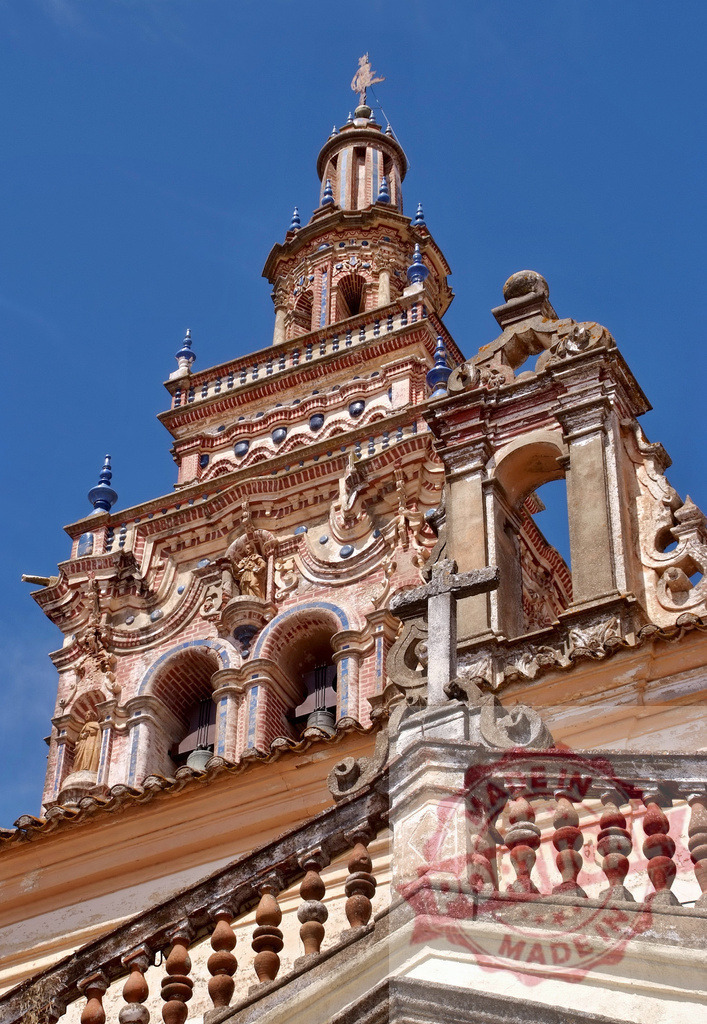 Church of the Assumption bell tower in Palma del Río. Extremdura - Spain | Ornate baroque church architecture rising against a clear blue sky in Andalusia, Spain - Realisiert mit Pictrs.com