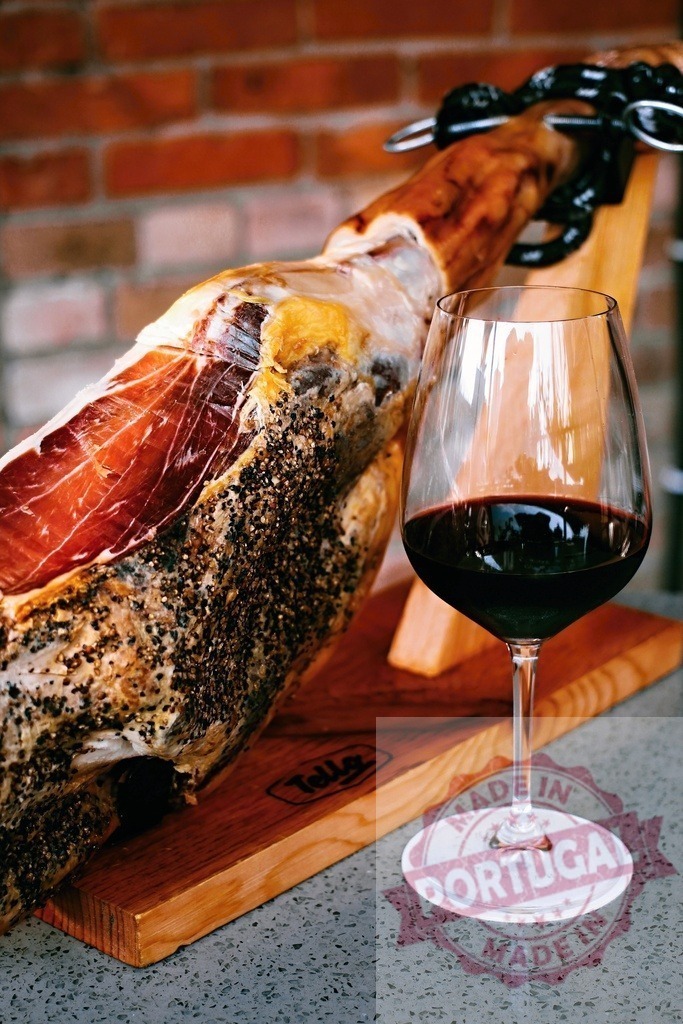 Jamon Serrano leg with red wine pairing | Cured jamon leg on a holder with a glass of red wine - Realisiert mit Pictrs.com