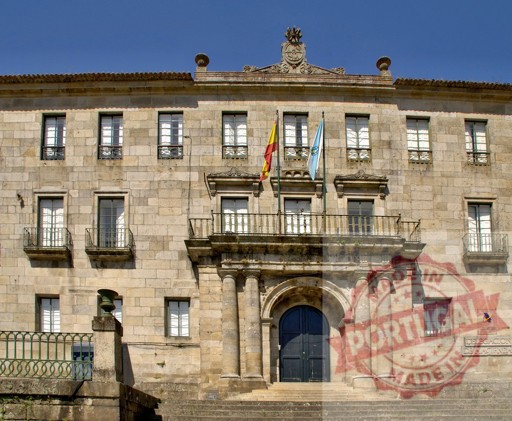 Delegación de Hacienda building in Santiago de Compostela. Galicia - Spain | Stone facade of the government building with flags flying under a blue sky - Realisiert mit Pictrs.com