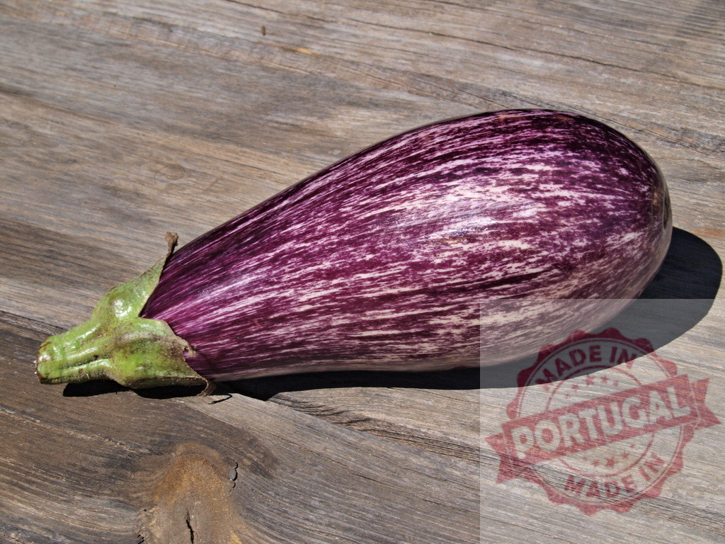 Striped organic eggplant resting on rustic wood | Striped purple eggplant showing a green stem, lying on an old wooden surface - Realized with Pictrs.com