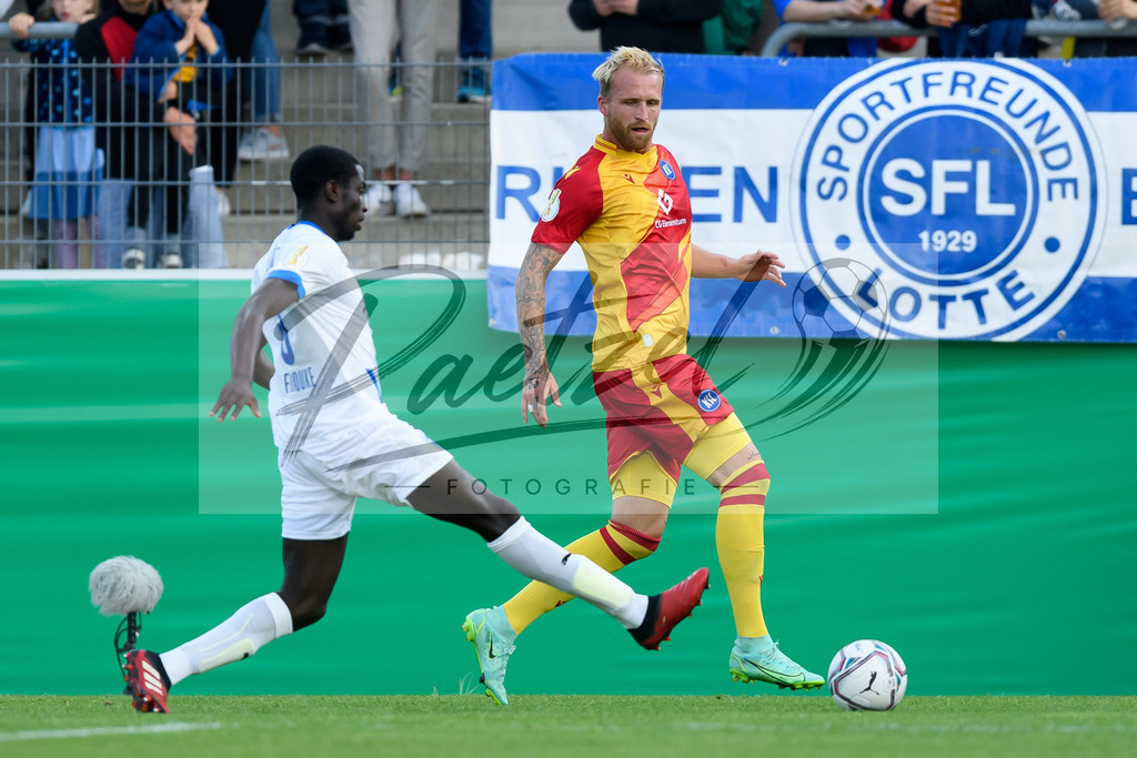 LOTKSC20210809_040 | Fussball, Herren: Philipp Hofmann (Karlsruher SC) und Komlan Fionouke (Sportfreunde Lotte) im Zweikampf beim Spiel der 1. Runde im DFB-Pokal zwischen SF Lotte und Karlsruher SC im Stadion am Lotter Kreuz am 09.08.2021 in Lotte, Deutschland.DFB / DFL REGULATIONS PROHIBIT ANY USE OF PHOTOGRAPHS AS IMAGE SEQUENCES AND/OR QUASI-VIDEO. - Realisiert mit Pictrs.com