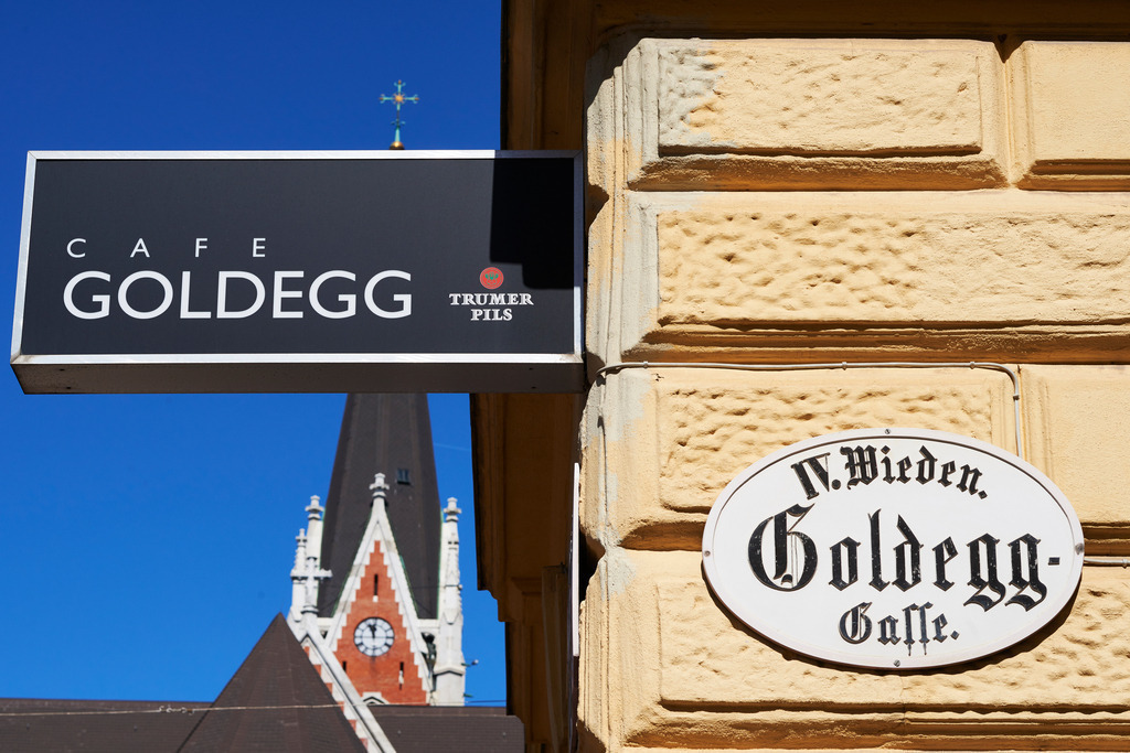 Cafe Goldegg | Wien, Austria - August 29, 2017: Cafe Goldegg Eingangsschild, im Hintergrund die Kirche St. Elisabeth. - Realisiert mit Pictrs.com