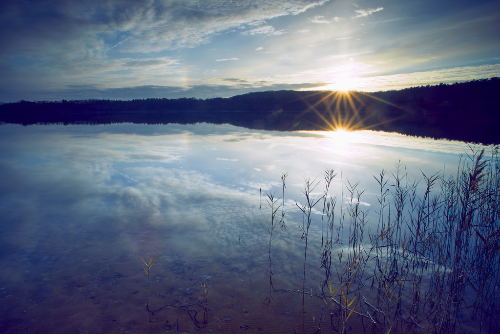 Winterabend am Drochower See, Deutschland | Blick vom Ufer des Drochower Sees auf die untergehende Sonne, deren Stern sich im kalten Wasser  spiegelt. Der Drochower See ist ein Überbleibsel des Niederlausitzer Braunkohlenbergbaus, der hier 1941 eingestellt wurde.Unsere Empfehlung: Alu-Dibond oder Acrylglas - Realisiert mit Pictrs.com