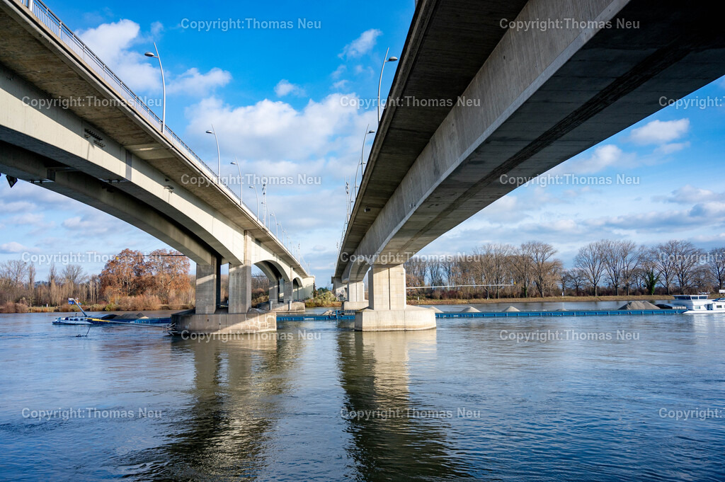 Nibelungenbruecke_Worms__Thomas_Neu_Fotografie-40 | Die Nibelungenbrücke verbindet die rheinland-pfälzische Stadt Worms über den Rhein mit den hessischen Städten Lampertheim und Bürstadt.Nachdem bei Worms der Fährbetrieb urkundlich seit dem Jahr 858 belegt ist, entstand die erste Schiffsbrücke im Jahr 1855. Die erste feste Brücke über den Rhein war von 1900 bis 1945 die Ernst-Ludwig-Brücke. Die im Zweiten Weltkrieg zerstörte Brücke wurde als Nibelungenbrücke (heute „alte“ Nibelungenbrücke genannt) von 1951 bis 1953 wieder aufgebaut.Die Nibelungenbrücke in Worms ist eine der wichtigsten Rheinquerungen der Region und prägt mit ihrem markanten Brückenturm das Stadtbild. Der Turm, ursprünglich als repräsentatives Stadttor zur Nibelungensage gestaltet, gilt bis heute als eines der bekanntesten Wahrzeichen von Worms. Die Brücke verbindet das rheinhessische und rheinland-pfälzische Ufer und bietet beeindruckende Ausblicke auf den Rhein, die Wormser Innenstadt und die umliegende Landschaft. Durch ihre besondere Architektur und historische Bedeutung ist die Nibelungenbrücke ein beliebtes Motiv für Fotografen und Besucher.,, Bild: Thomas Neu