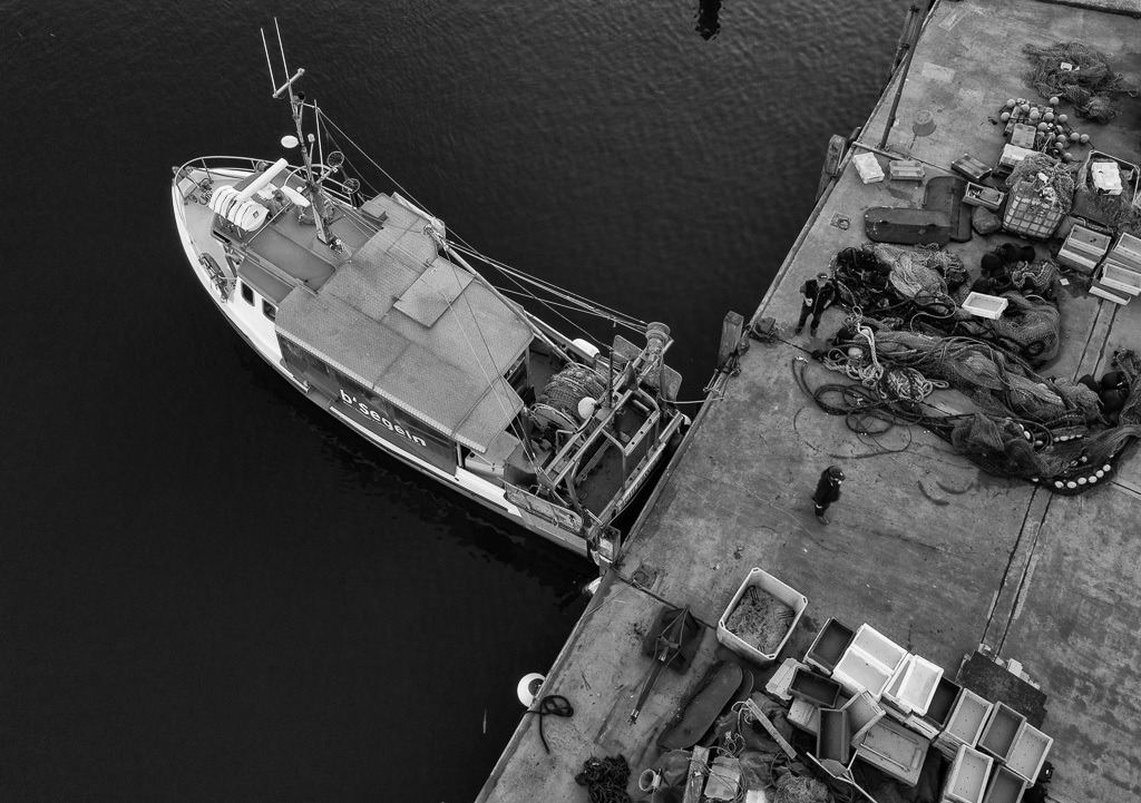 fischer-DJI_0059 | Christian Ross ist der jüngste unter den Fischern vom Holm in Schleswig an der Schlei. Er fischt am liebsten allein in seinem Kutter "Schle 26" auf der Ostsee. Hier montiert Christian Ross ein neues Schleppnetz am Liegeplatz des Schiffes im Hafen von Kappeln. - Realisiert mit Pictrs.com