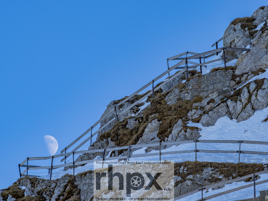 Mondaufgang am Pilatus Esel | <p><strong>Mond. Fels. Stille.</strong></p>
<p>Der blasse Tagesmond schiebt sich sanft hinter dem schroffen Grat des Esels hervor. Ein stilles Schauspiel am helllichten Tag, das die raue Schönheit der Innerschweizer Bergwelt auf minimalistische Weise unterstreicht.</p>
<p>Wähle unter "Produktauswahl" dein Wunschformat: Vom klassischen Wandbild über Puzzle & Tassen bis zum digitalen Download (z.B. als Handy-Hintergrund).</p>
<br> - Realisiert mit Pictrs.com