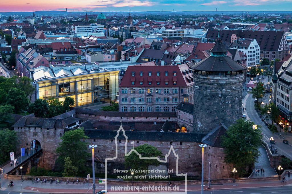 Mischung der Epochen | Auf diesem Bild finden Sie die historische Stadtmauer mit dem Frauentorturm im Vordergrund zur Dämmerung über Nürnberg. Als Kontrast sehen Sie das bereit beleuchtete Neue Museum direkt hinter der Stadtmauer. Im Hintergrund sieht man die Altstadt von Nürnberg. - Realisiert mit Pictrs.com