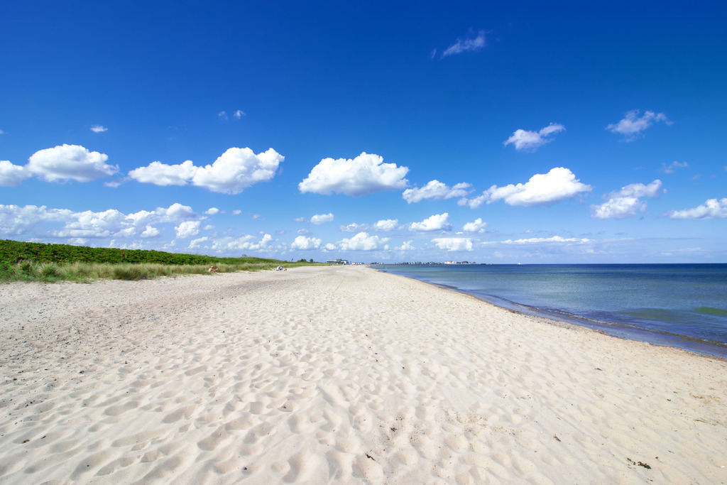 XXL Wandbild: Weite und Ruhe am Ostseestrand – Leinwandbild | Dieses beeindruckende Wandbild im Großformat fängt die vollkommene Stille und die unendliche Weite der Ostküste ein. Das Motiv zeigt einen strahlend hellen, feinsandigen Strand, der sich unter einem tiefblauen Himmel mit malerischen Schönwetterwolken bis zum Horizont erstreckt. Das ruhige Meer geht in sanften Nuancen von hellem Türkis in tiefes Blau über und vermittelt eine Atmosphäre von grenzenloser Freiheit. Diese maritime Szenerie strahlt eine tiefe Ruhe aus und verleiht Ihren Räumen eine luftige, positive Ausstrahlung, die zum Durchatmen einlädt. Besonders in einladenden Praxen, modernen Bürolandschaften oder im großzügigen heimischen Wohnbereich setzt dieses Leinwandbild einen exklusiven Akzent, der sofort ein Gefühl von nordischer Gelassenheit vermittelt. Die moderne 6-Tinten-Drucktechnologie bringt dabei das strahlende Weiß des Sandes und das intensive Blau des Himmels auf dem hochwertigen, 260 g/m² schweren Leinwandgewebe brillant zur Geltung. In professioneller Handarbeit wird das reißfeste Material auf einen stabilen Holzkeilrahmen aus FSC-zertifizierter Forstwirtschaft aufgezogen, was für dauerhafte Formstabilität und eine edle Galerie-Optik sorgt. - Realisiert mit Pictrs.com