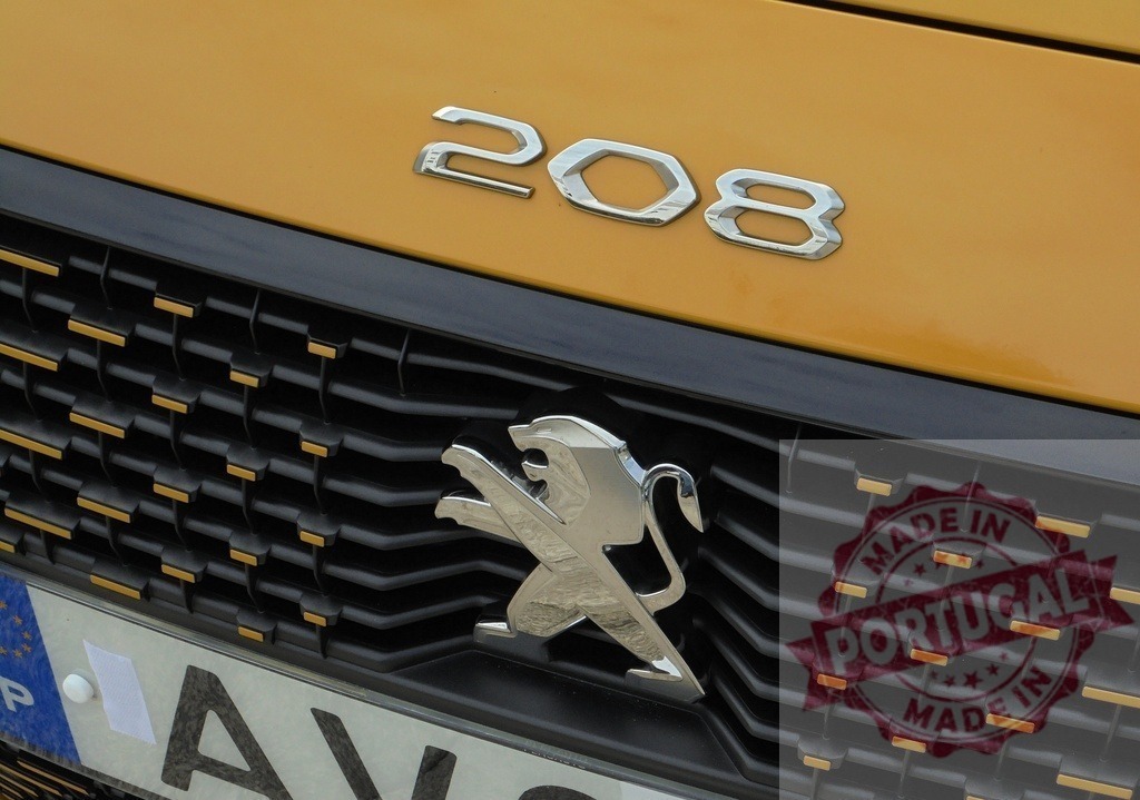 Peugeot 208 car emblem on gold painted radiator grille | Peugeot 208 model name and lion logo on the front grille of a modern yellow car - Realisiert mit Pictrs.com