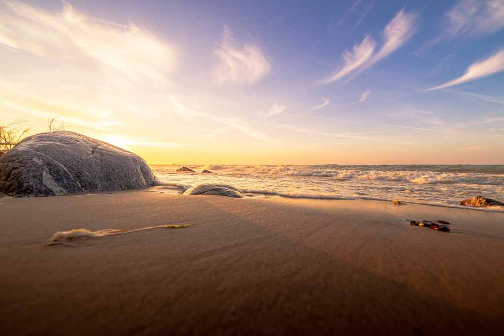 Strand von Stohl | Das Bild zeigt goldenen Sand, der das warme Abendlicht der untergehenden Sonne reflektiert.