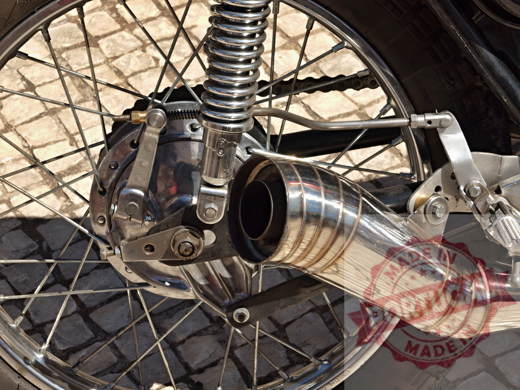 Vintage motorcycle wheel exhaust and shock absorber | Close up view of classic motorcycle rear wheel with chrome exhaust and suspension - Realisiert mit Pictrs.com