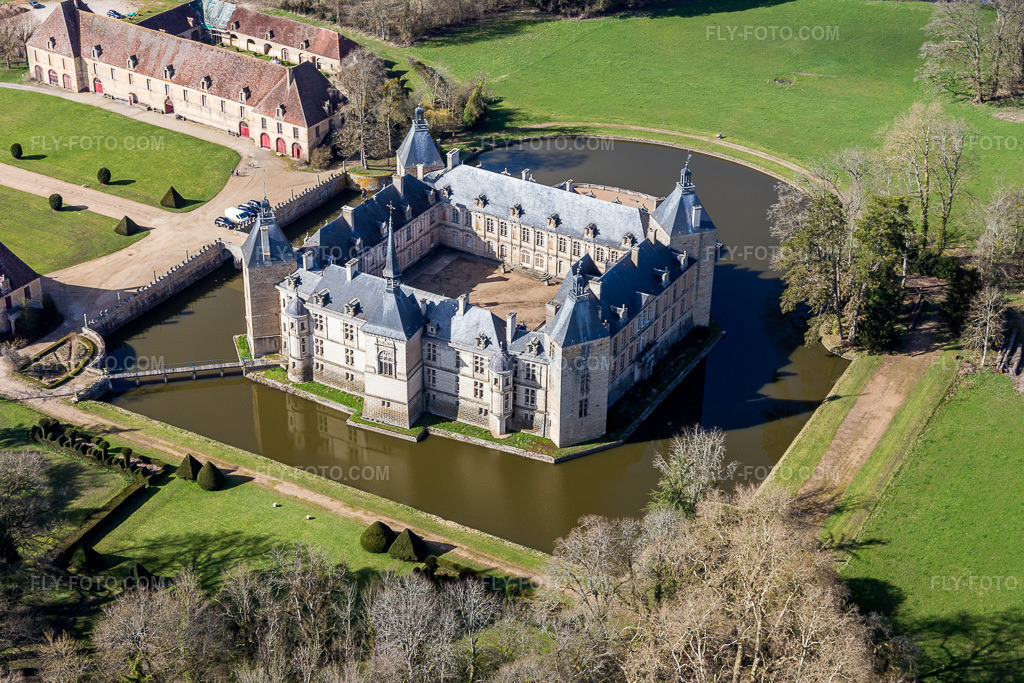 Aerial view: Buildings and castle park facilities of the moated castle Sully in Sully in the state Saone et Loire, France. – Photo: IMG_105442.jpg taken on 04/01/2018 by Werner Riehm/FLY-FOTO.com – Resolution of the original: 4920 x 3280 px