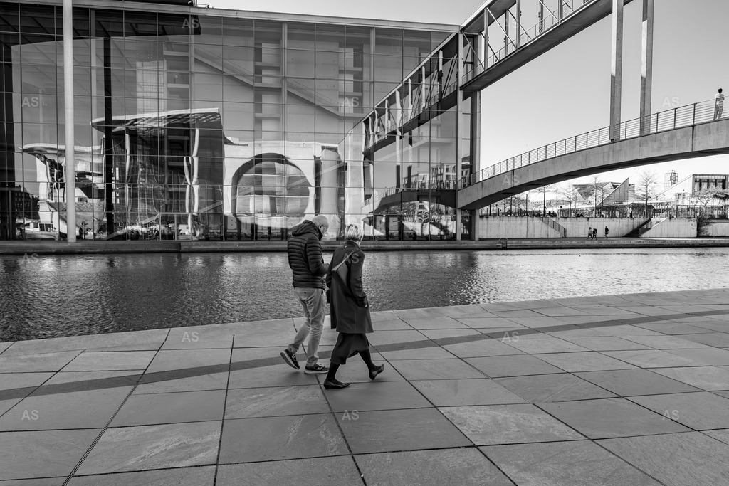 Reflections of Power | A quiet urban moment captured in Berlin’s government district.The mirrored architecture and clean geometry reflect both order and introspection. This black and white composition explores the calm intersection of structure, reflection, and human movement.A quiet meditation on balance and order. - Realisiert mit Pictrs.com