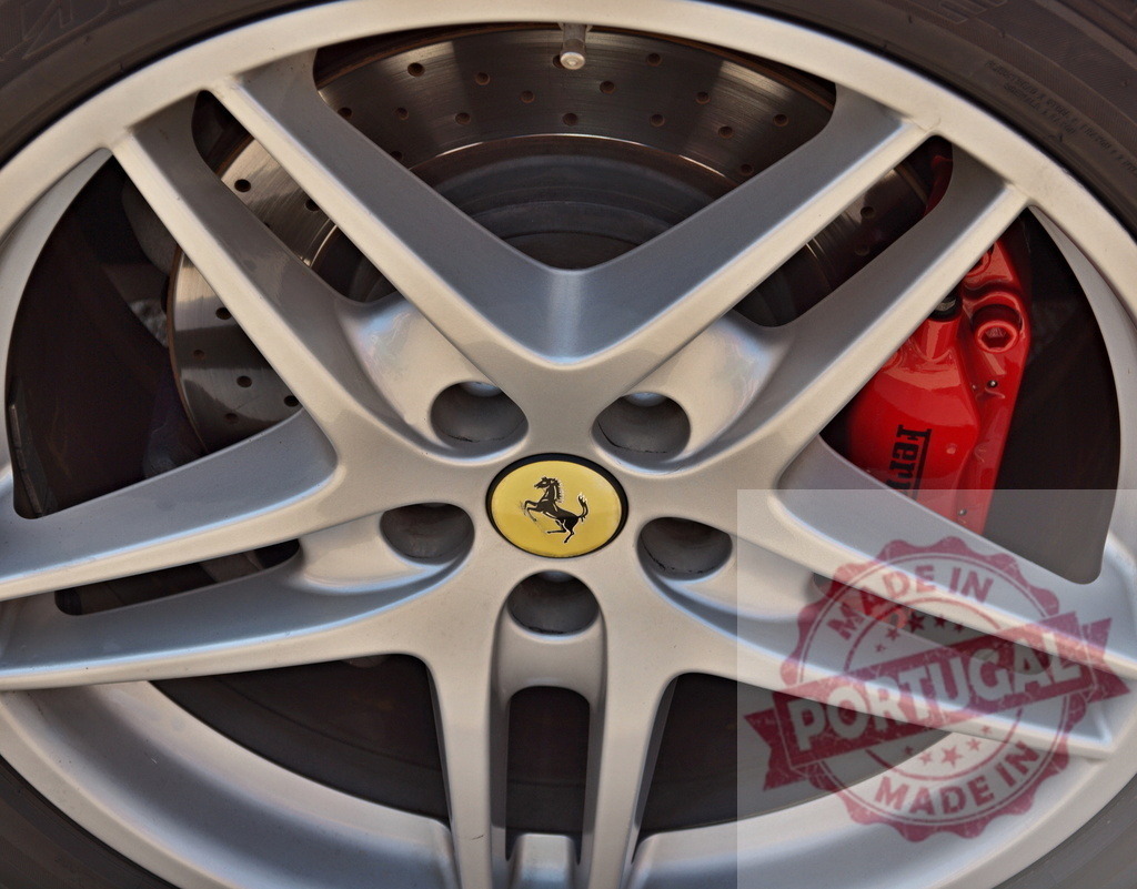 Ferrari wheel showing prancing horse logo and red brake caliper | Close-up of a Ferrari wheel featuring the iconic prancing horse logo and a red brake caliper - Realisiert mit Pictrs.com