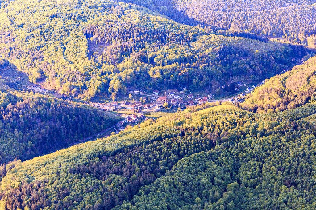 Aerial view: Evening view of a village in a valley of the Northern Vosges Mountains, seen from the southeast. in Soucht in the state Moselle, France. – Photo: IMG_145785.jpg taken on 04/30/2025 by Werner Riehm/FLY-FOTO.com – Resolution of the original: 5472 x 3648 px