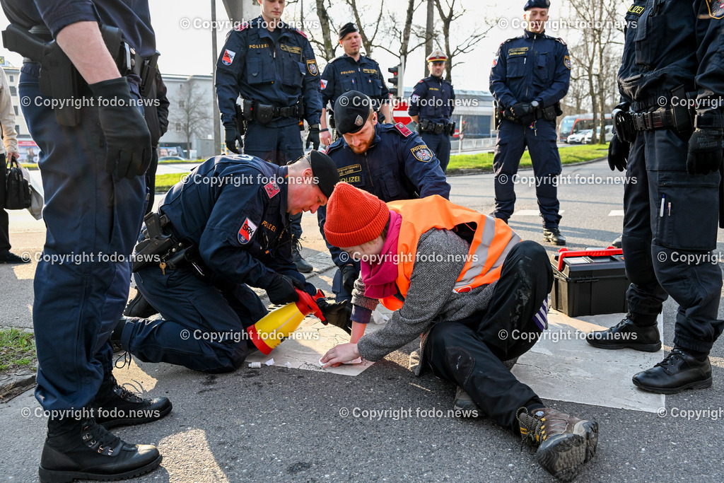  Klimagegner Linz Waldeggstrasse_ Klimakleber_ 20.03.2023-79 | 20.03.2023, Linz, AUT, Klimagegner Linz Klimakleber, im Bild Klimagegner kleben auf der Strasse, Linz Waldeggstrasse, Polizei, Verkehr, Zebrastreifen, Fussgaengeruebergang, Transparent, Demo, Klimawandel