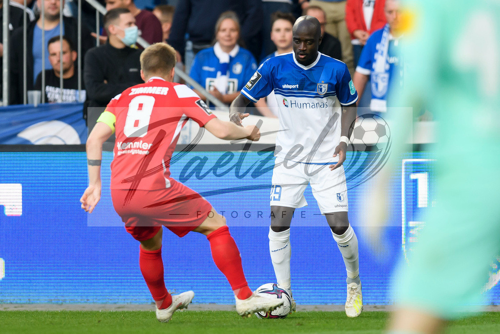 FCMFCK20210904_171 | Fussball, Herren: Jean Zimmer (1. FC Kaiserslautern) und Amara Conde (1. FC Magdeburg) im Zweikampf beim Spiel der 3. Liga zwischen 1. FC Magdeburg und 1. FC Kaiserslautern in der MDCC-Arena am 04.09.2021 in Magdeburg, Deutschland.DFB / DFL REGULATIONS PROHIBIT ANY USE OF PHOTOGRAPHS AS IMAGE SEQUENCES AND/OR QUASI-VIDEO. - Realisiert mit Pictrs.com