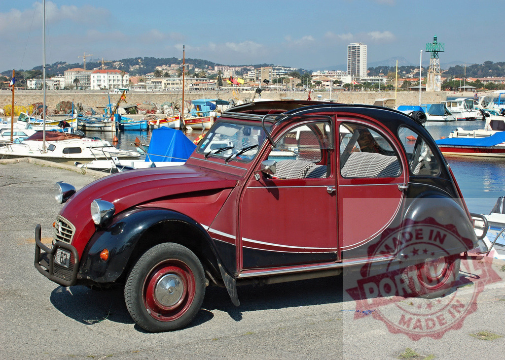 Classic Citroën 2CV parked near the harbor in Sanary-sur-Mer, France | Vintage Citroën 2CV car parked on the pier, overlooking the boats and the city of Sanary-sur-Mer in the background - Realisiert mit Pictrs.com