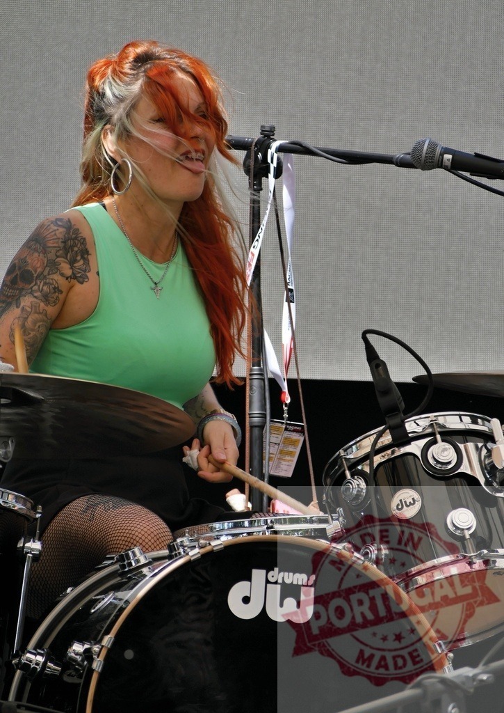 Woman drummer performing live on stage concert | Woman drummer with red hair and tattoos playing drums on stage - Realisiert mit Pictrs.com
