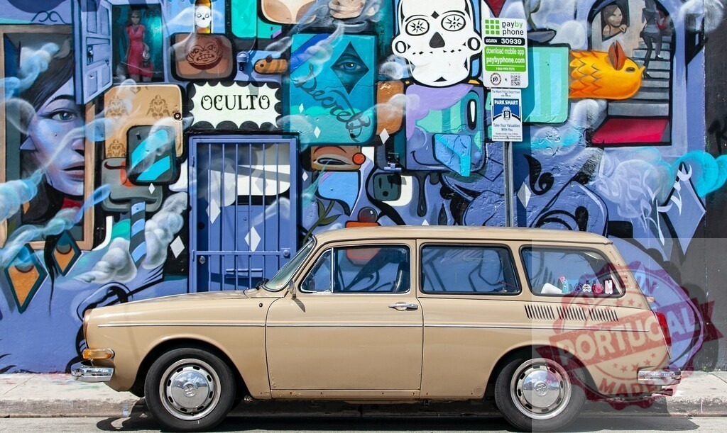 Volkswagen wagon car parked by urban street art mural | Vintage Volkswagen parked next to colorful graffiti wall featuring skulls and Oculto word - Realisiert mit Pictrs.com