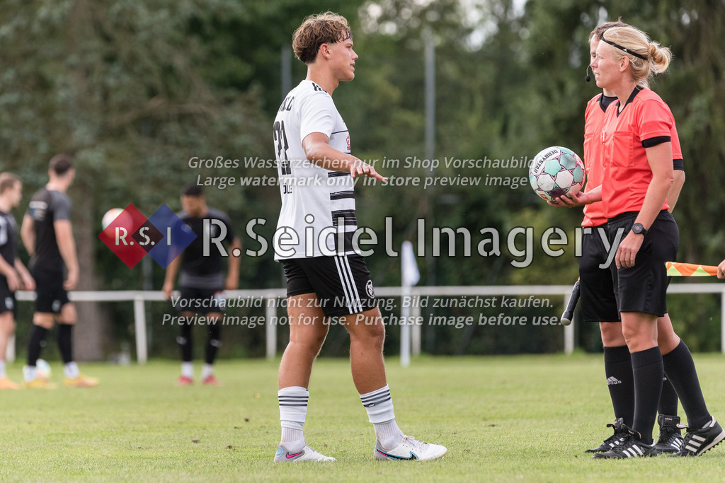 RS-1-001873 | Dominik Möller (#22, Reinfeld) spricht mit den Schiedsrichtern und der Schiedsrichterin in der Halbzeitpause.