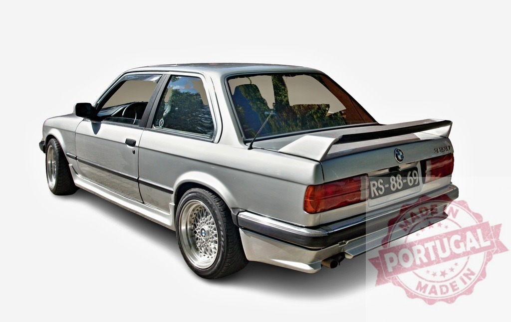 Silver BMW E30 showing its rear and right side | Tuned silver BMW E30 with custom rims, spoiler and bodykit is showing its rear and right side - Realized with Pictrs.com
