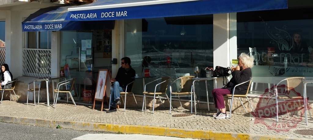 People enjoying outdoor pastry shop in Portugal | Customers relaxing at tables outside Pastelaria Doce Mar in a sunny European street - Realisiert mit Pictrs.com