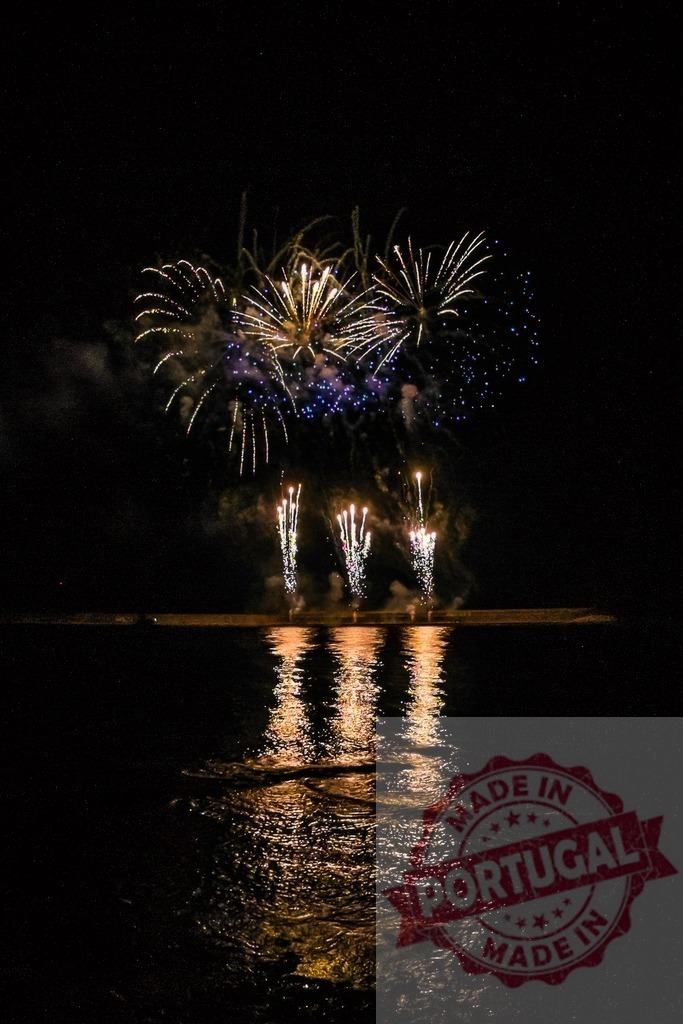 Fireworks exploding over water at night | Colorful firework display illuminating the night sky and reflecting on the calm water surface - Realized with Pictrs.com