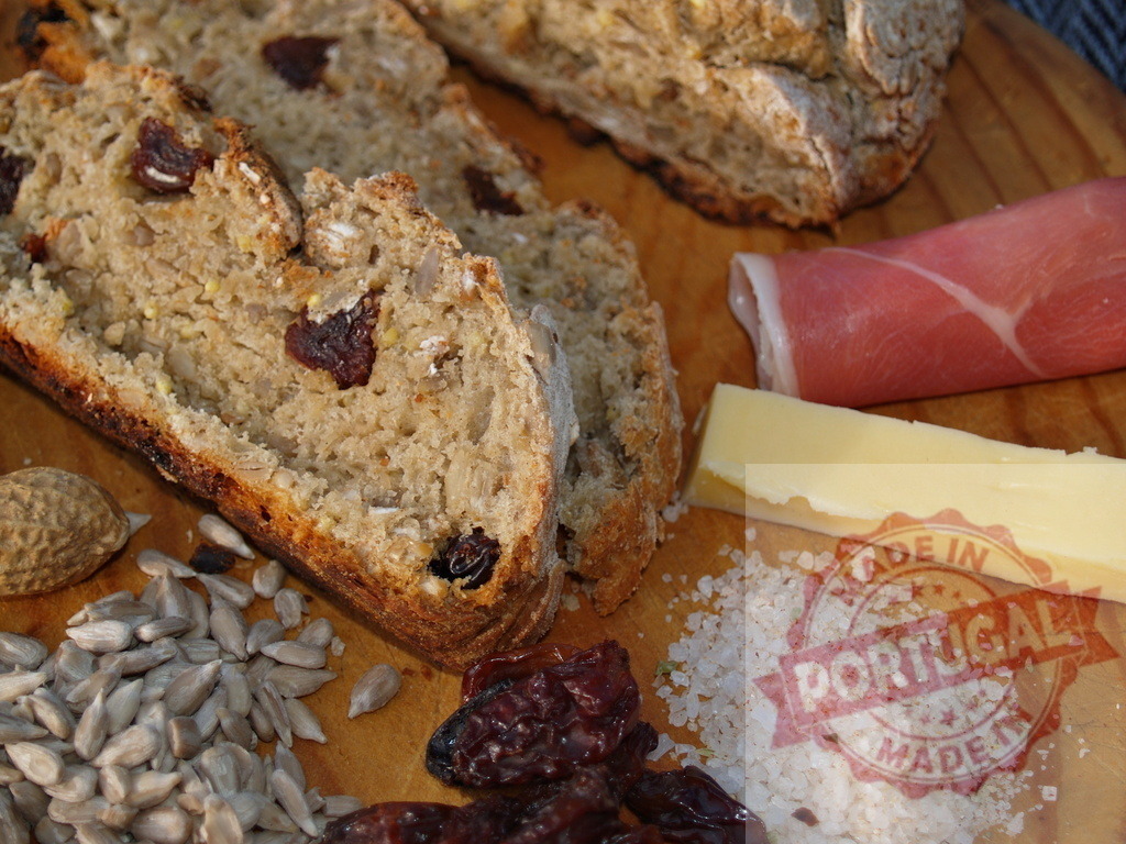 Rustic multi-grain bread with raisins and seeds board | Rustic bread slices with prosciutto, cheese, sea salt, dried fruit, and seeds - Realisiert mit Pictrs.com