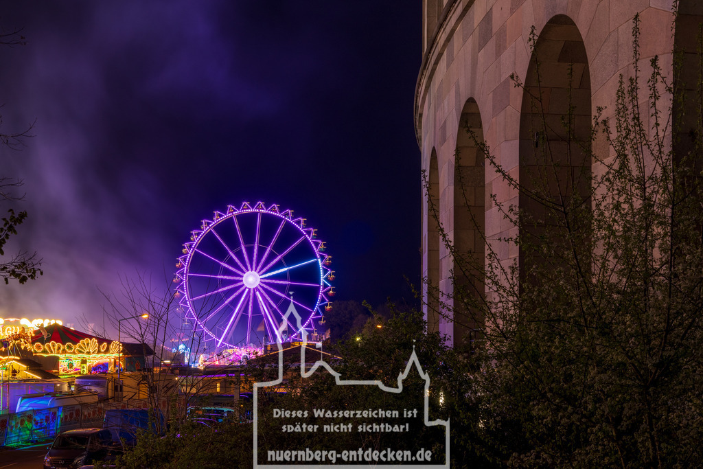 Riesenrad neben alter Kongresshalle | Nach langer Corona-Pause hatte im April 2022 wieder das Volksfest auf dem Reichsparteitagsgelände Nürnberg stattgefunden. Auf dem Bild das schön beleuchtete Riesenrad direkt neben der alten Fassade der historischen und nicht fertiggestellten Kongresshalle zu sehen. - Realisiert mit Pictrs.com