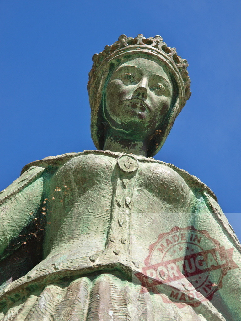 Catherine of Aragon bronze statue against blue sky | Ornate bronze statue of Catherine of Aragon wearing a crown, seen from a low angle - Realisiert mit Pictrs.com