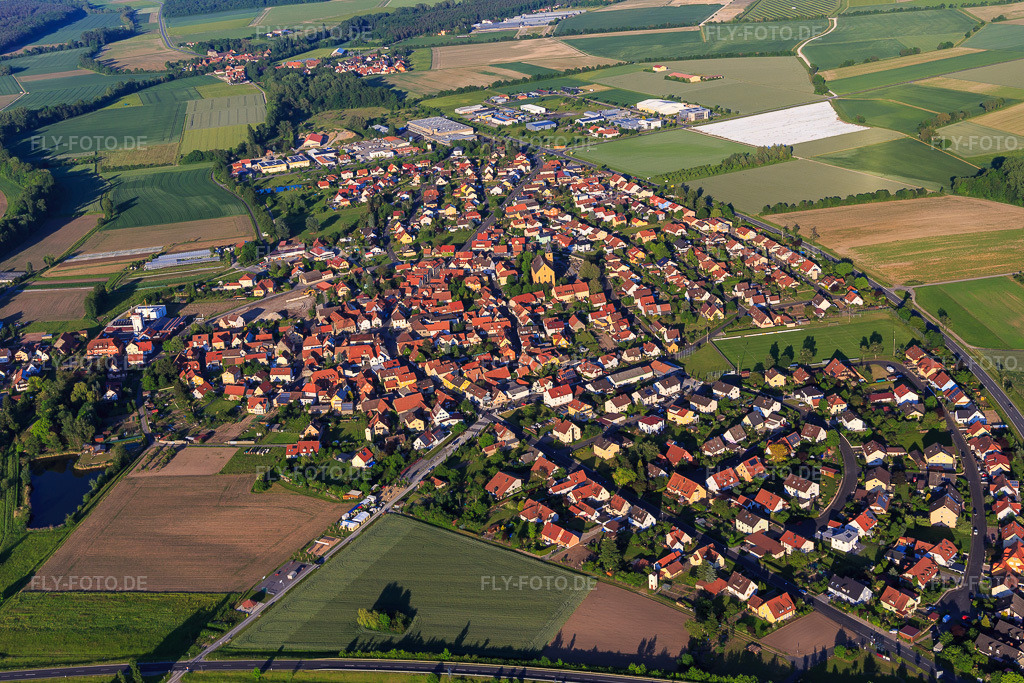 Luftbild: Ortsansicht von Westen mit Heilig Kreuz Kirche im Ortsteil Stadtschwarzach in Schwarzach im Bundesland Bayern in Deutschland. – Foto: IMG_100359.jpg vom 27.05.2017 durch Werner Riehm/FLY-FOTO.de – Auflösung des Originals: 5472 x 3648 px – Pfarreiengemeinschaft Stadtschwarzach - Sankt Benedikt