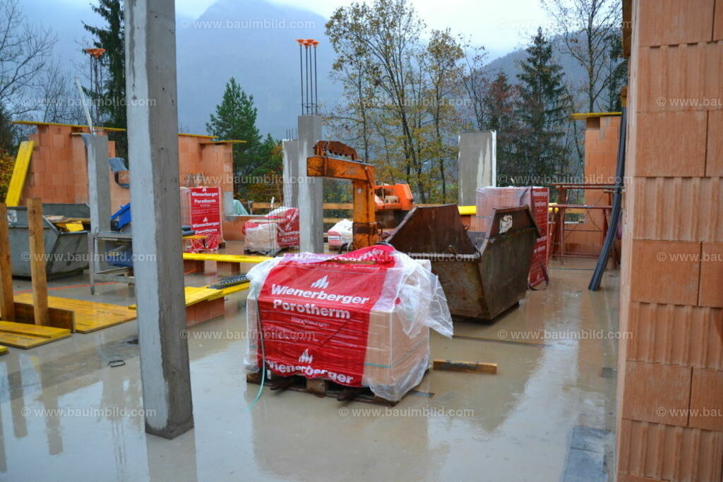 Baustelle bei Regenwetter | Betonstützen und Ziegelmauerwerk auf betonierter Geschoßdecke
