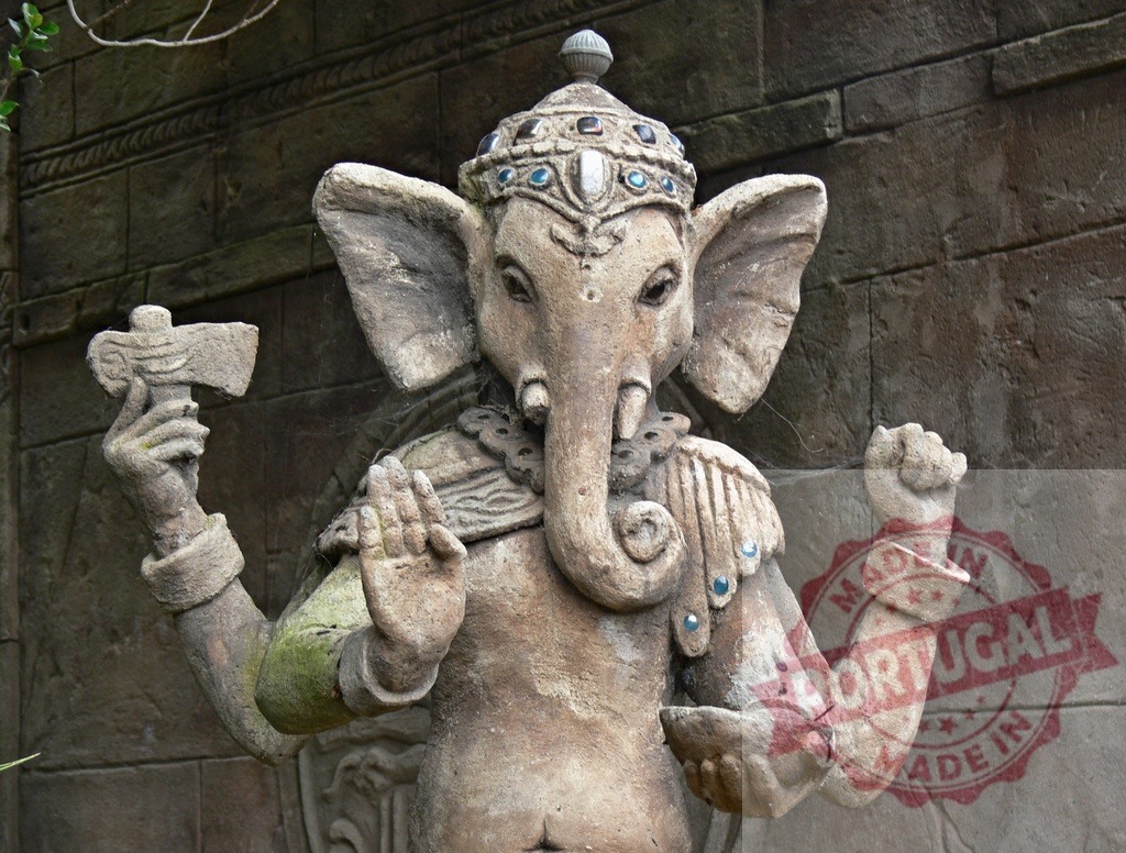Ganesha elephant god statue symbolizing wealth and good fortune | Stone sculpture of Hindu deity Ganesha standing against a stone wall - Realisiert mit Pictrs.com