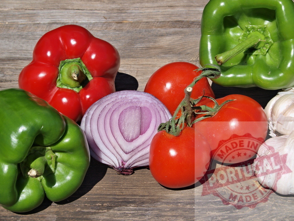 Fresh organic vegetables on rustic wood surface | Colorful healthy vegetables, including bell peppers, tomatoes, onion, and garlic, resting on wood - Realized with Pictrs.com