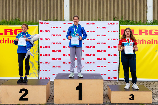 DLRG, Wettkampf, Rettungssport, Landesverbandsmeisterschaften 2026 13.06.2026 | Bedburg, Deutschland - June, 13: Siegerehrung der AK12 weiblich der Landesverbandsmeisterschaften 2026 im MonteMare Bedburg. Platz 2: Sophie Naser (DLRG OG Bedburg), Platz 1:  Lilly Welms (DLRG OG Hochneukirch), Platz 3: Cora Deimann (DLRG Bezirk Mönchengladbach). (Foto: Benedikt Lang (DLRG) - Realisiert mit Pictrs.com