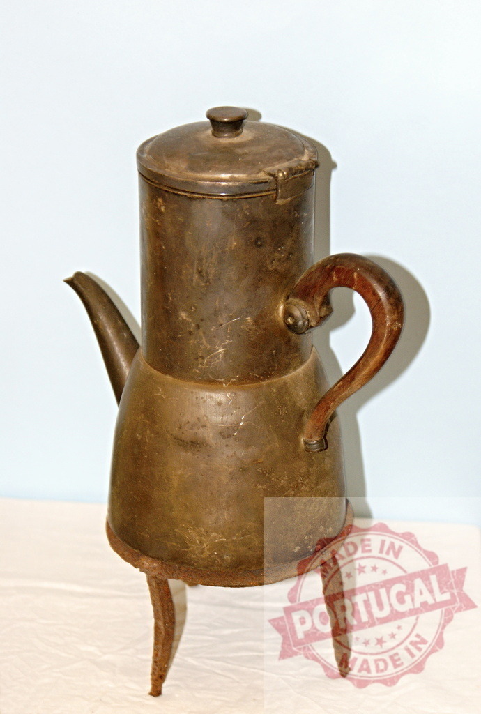Antique copper coffee pot on three legs | Vintage copper coffee pot with wood handle, spout, and tripod base against a light background - Realized with Pictrs.com