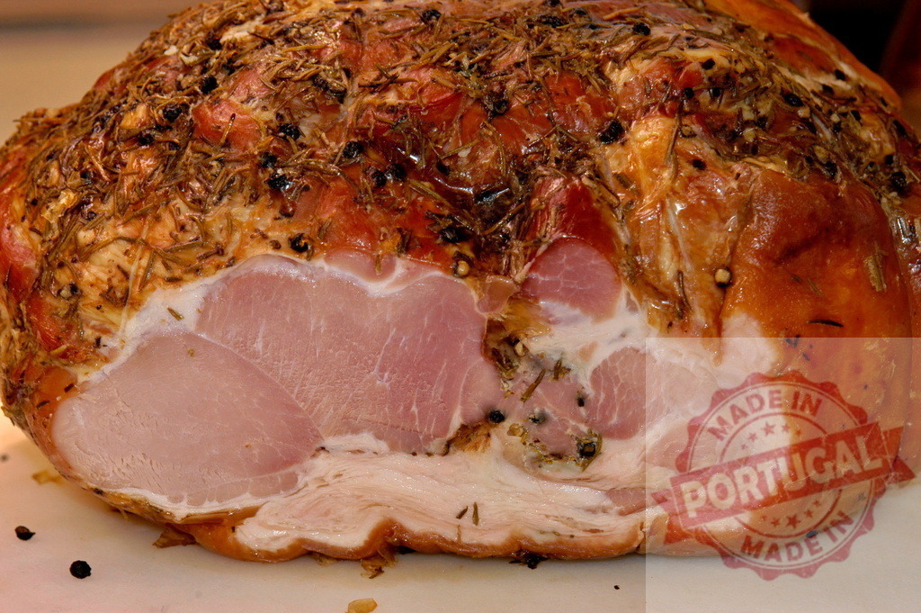 Roasted ham joint seasoned with rosemary and peppercorns | Large roasted pork ham on a white surface, showing inside texture - Realisiert mit Pictrs.com