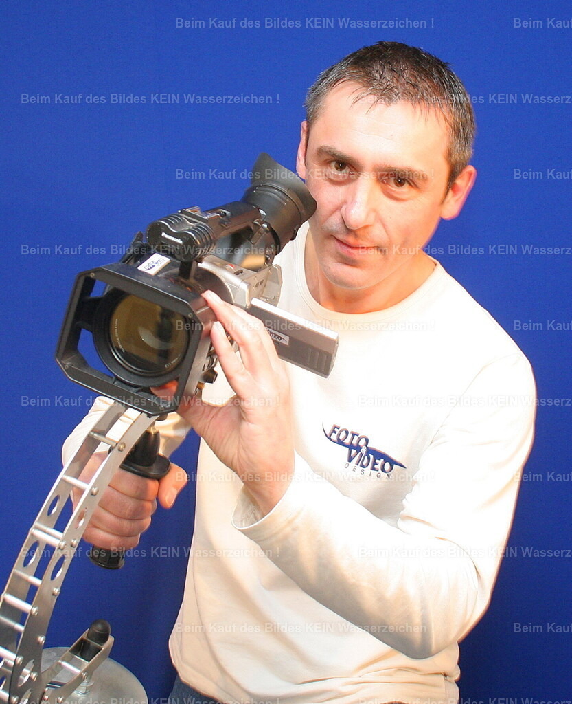 steffen2-- | Die Idee ---Manchmal beginnt ein neues Lebenskapitel ganz unscheinbar – mit einer Kamera, einer großen Portion Neugier und dem Mut, einfach anzufangen.---Dieses Foto zeigt mich mit meiner ersten Steadycam. Ich war 40 Jahre alt, voller Ideen und stolz darauf, zum ersten Mal ein T-Shirt mit meinem eigenen Logo „Foto Video Design“ zu tragen. In diesem Moment wusste ich nicht, wohin mich dieser Weg führen würde. Aber ich wusste, dass ich ihn gehen wollte.---Damals fotografierte und filmte ich alles, was mich begeisterte. Hochzeiten, Veranstaltungen, Menschen und besondere Momente. An Luftbilder, Drohnen oder einen Tragschrauber dachte ich noch nicht. Ich wollte einfach gute Bilder machen und mich mit jeder Aufnahme weiterentwickeln.---Rückblickend war genau dieser Moment der Anfang eines großen Abenteuers. Aus einem Hobby wurde Schritt für Schritt ein Beruf, aus einer Idee ein Unternehmen und schließlich meine Leidenschaft für die Luftbildfotografie. ---Wenn ich dieses Foto heute sehe, muss ich schmunzeln – und bin gleichzeitig dankbar, dass ich damals den Mut hatte, diesen ersten Schritt zu gehen. - Realisiert mit Pictrs.com