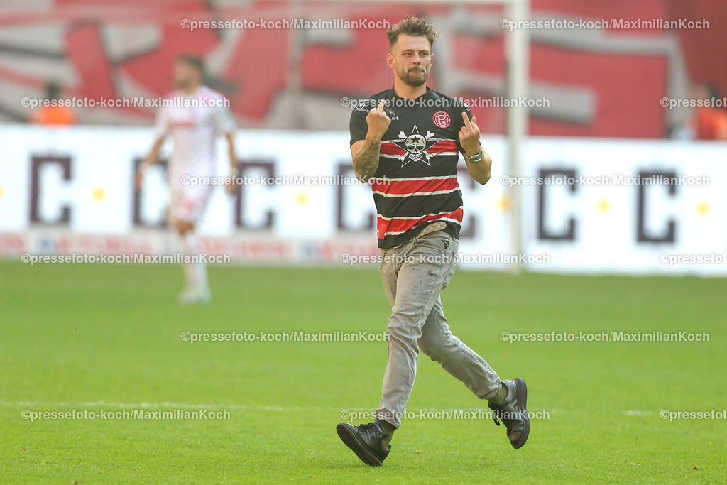 Due21092401046 | 21.09.2024, 2. Fußball Bundesliga, Fortuna Düsseldorf - 1. FC Köln, Merkur Spiel-Arena, Saison 2024 2025: Ein Flitzer läuft nach dem Tor zum 2:2 jubelnd und gestikulierend auf dem Kölner Gästeblock zu.DFB regulations prohibit any use of photographs as image sequences and or quasi-video.