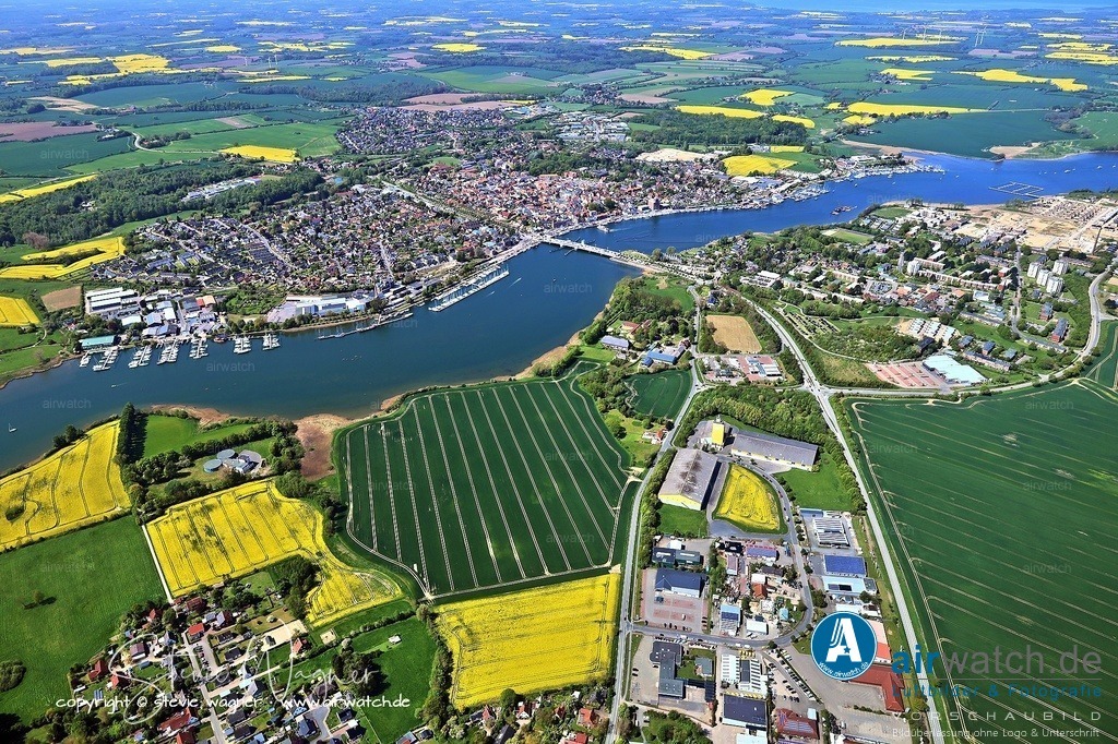 Luftbild Kappeln an der Schlei | Die evangelische St. Nikolai Kirche, zwischen 1789 und 1793 erbaut, ist ein herausragendes Beispiel spätbarocker Architektur. Ihr Fundament besteht aus Steinen alter Großsteingräber. Innen beeindruckt ein barocker Schnitzaltar von Hans Gudewerdt dem Jüngeren (1641), der bei der Kirchenrenovierung 1793 neu zusammengesetzt wurde. Ebenfalls sehenswert sind die böhmischen Kristallleuchter und die Christopherus-Figur im Eingangsbereich. Die Kirche steht auf dem Rathausmarkt und ist ein zentraler Punkt beim Stadtbummel.