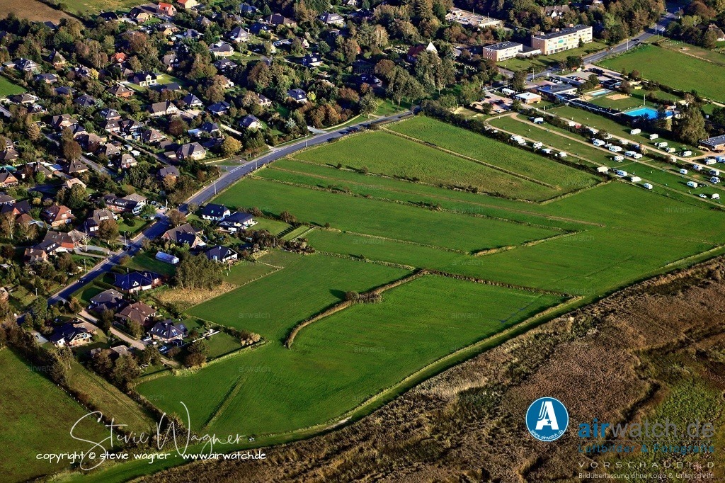 Luftbild Husum-Schobüll - Ein besonderes Merkmal ist, dass Schobüll der einzige Abschnitt der schleswig-holsteinischen Festlandküste ist | Ein besonderes Merkmal ist, dass Schobüll der einzige Abschnitt der schleswig-holsteinischen Festlandküste ist, an dem die Geest direkt ins Wattenmeerbecken der westlich vorgelagerten Nordsee herabgleitet, weshalb der Ort bisher nicht durch eine vorgelagerte Deichlinie geschützt werden musste.