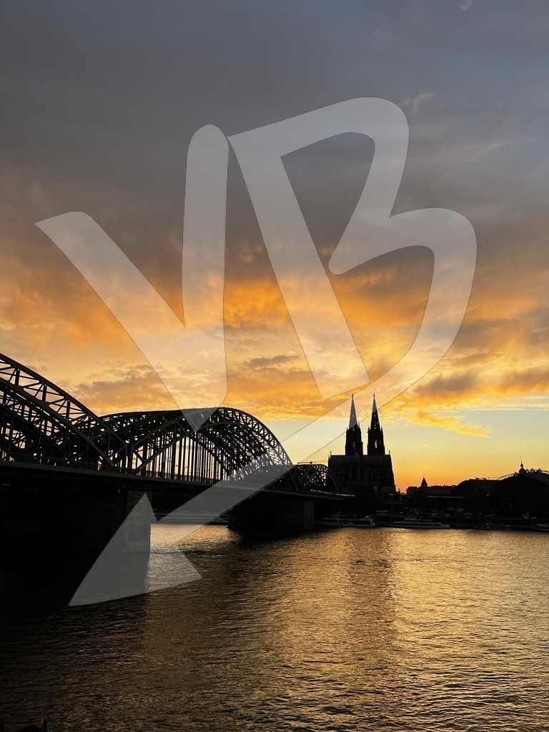 Dom | Beneath clouds in motion, the Cologne Cathedral remains.A bridge above the Rhine, carrying what passes. - Realisiert mit Pictrs.com