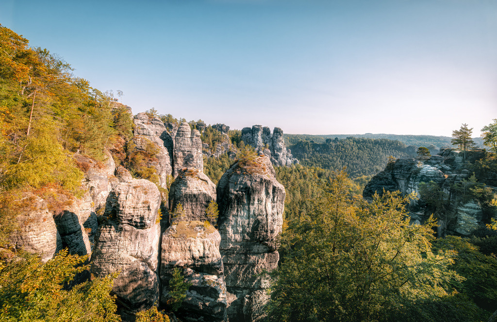 Strahlendes Elbsandsteinpanorama am Malerweg-Sächsische Schweiz | Dieses Bild zeigt die beeindruckenden Sandsteinfelsen im Nationalpark Sächsische Schweiz, einer Region im Elbsandsteingebirge.Die Gegend ist bekannt für ihre bizarren Felsformationen und spektakulären Ausblicke, ähnlich wie amerikanische Canyons.Die Bastei ist eine der berühmtesten Felsformationen in diesem Gebiet, gelegen in der Nähe von Dresden und Rathen.Der 112 Kilometer lange Malerweg führt Wanderer durch diese Landschaft, inspiriert von Künstlern der Romantik - Realisiert mit Pictrs.com