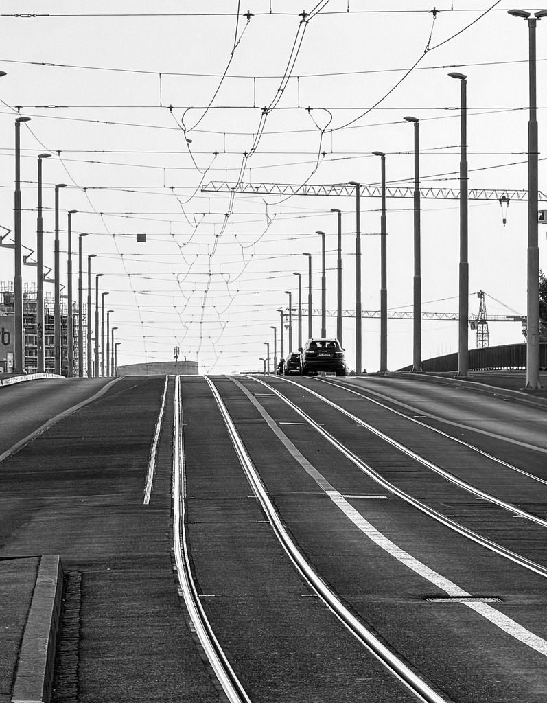 Urban Lines Basel – Symmetrische Fluchtlinien am Knotenpunkt Klybeck | Erleben Sie urbane Dynamik und architektonische Symmetrie in Perfektion. Diese minimalistische Fotokunst-Aufnahme fängt die kraftvollen Linienstrukturen an der Basler Haltestelle Dreirosenbrücke / Klybeck mit dem Blick nach oben ein. Die parallel verlaufenden Straßenbahnschienen und das geometrische Netz der Oberleitungen erzeugen eine fesselnde Tiefenwirkung, die den Blick magnetisch anzieht. Ein zeitloses Kunstwerk für Liebhaber moderner Metropolen-Ästhetik, das Lofts, minimalistischen Wohnzimmern oder urban gestalteten Büros und Konferenzräumen eine strukturierte, moderne Eleganz verleiht.Material-Empfehlung: Für diesen industriellen, rauen Charakter empfehle ich dieses Motiv ganz klar auf mattem Alu-Dibond. Die reflexionsfreie Oberfläche bringt die metallischen Linien der Schienen und Masten spektakulär zur Geltung und unterstreicht den rauen Street-Look.Holen Sie sich ein Stück markante Basler Industriearchitektur nach Hause – wählen Sie jetzt Ihre Wunschgröße und bestellen Sie dieses edle Design-Statement.[Archiv-Nr. #0107] - Realisiert mit Pictrs.com